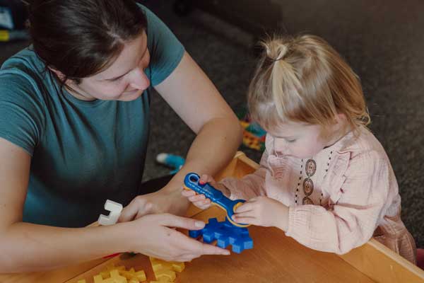 Woman sitting at a table pwith a child.