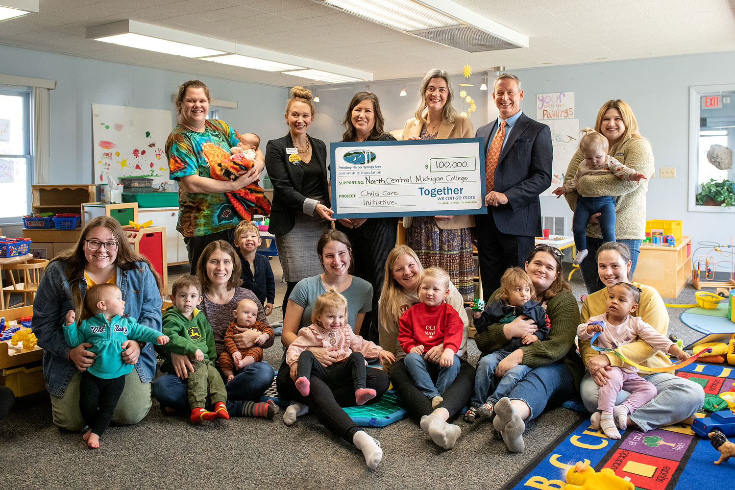Group of people and children smiling during a check presentation