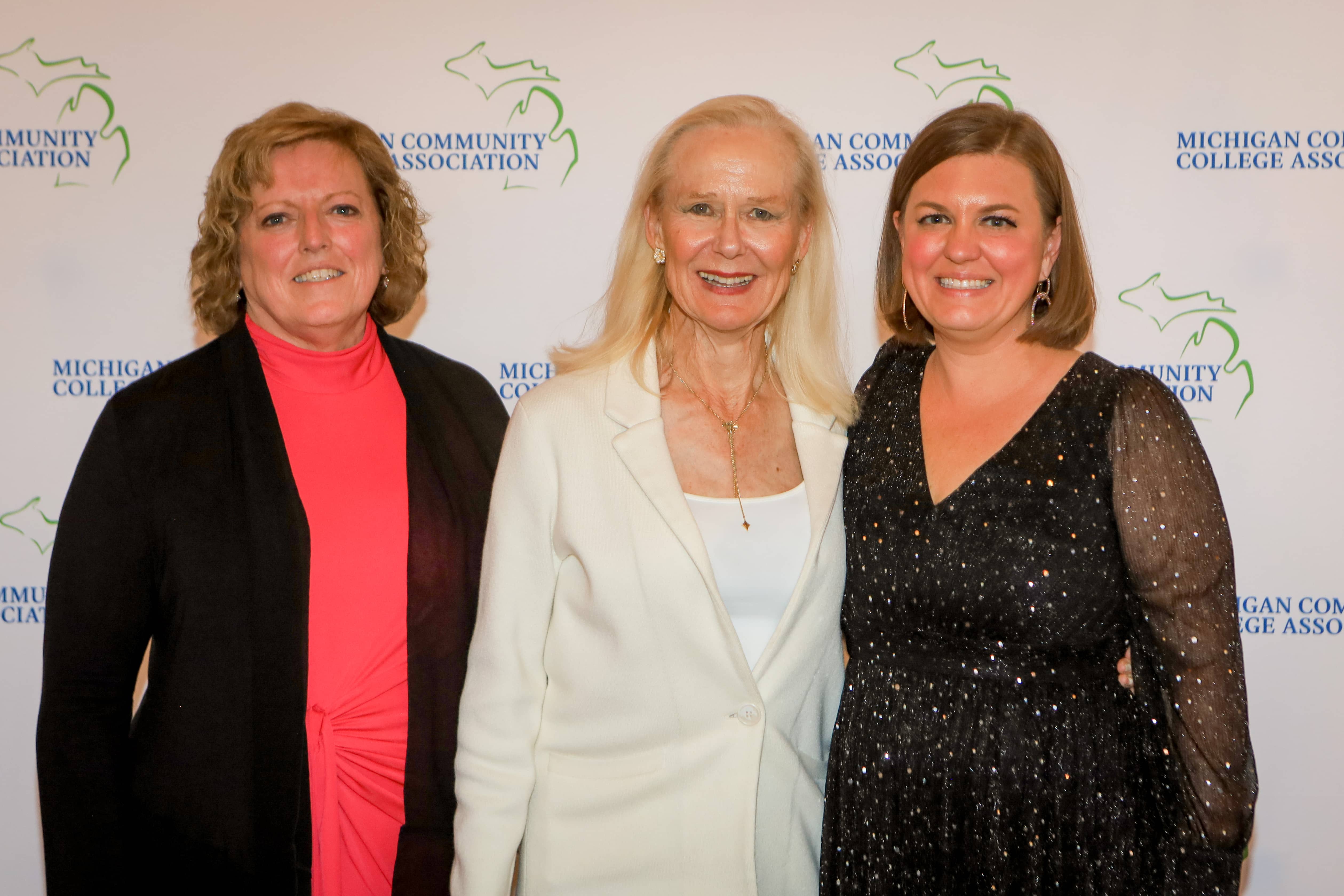 Melissa Keiswetter stands between Sherry Wyman and Brandy Johnson while being recognized for 10 years of service on the Michigan Community College Association Board of Directors at the MCCA Summer Conference on Mackinac Island.