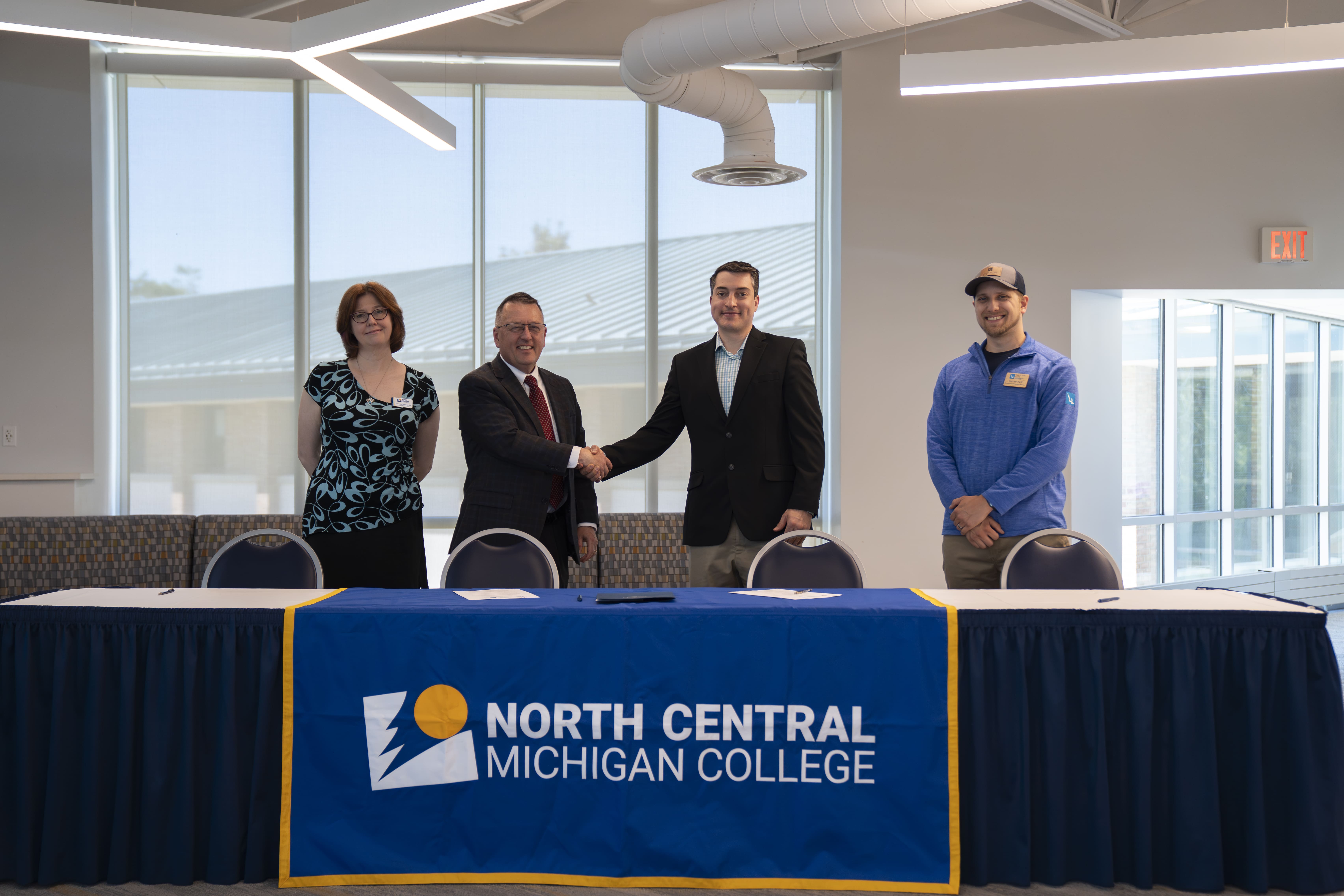 Representatives from North Central Michigan College and Walloon Lake Association and Conservancy stand together after signing a partnership renewal agreement in the Borra Learning Center on North Central’s Petoskey campus.